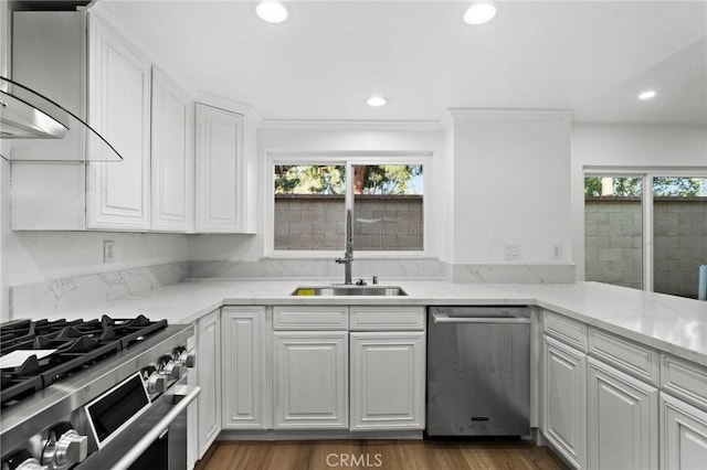 kitchen with appliances with stainless steel finishes, a sink, white cabinetry, and recessed lighting