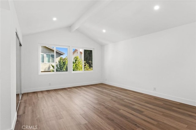empty room featuring lofted ceiling with beams, baseboards, wood finished floors, and recessed lighting