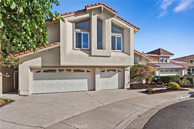 view of front of property featuring driveway, an attached garage, and stucco siding