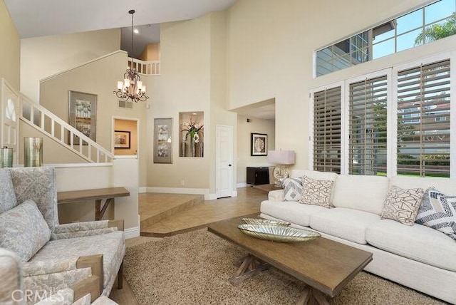 living area featuring a high ceiling, baseboards, and a notable chandelier