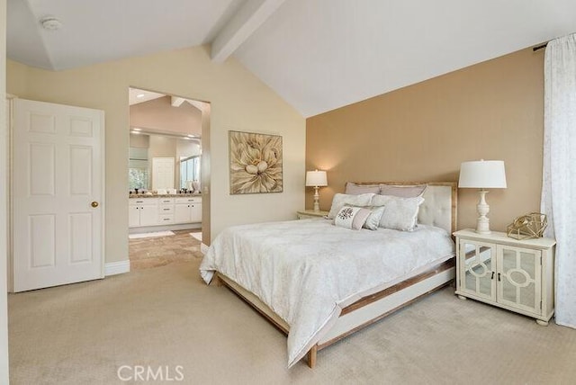 bedroom featuring vaulted ceiling with beams, ensuite bath, and carpet