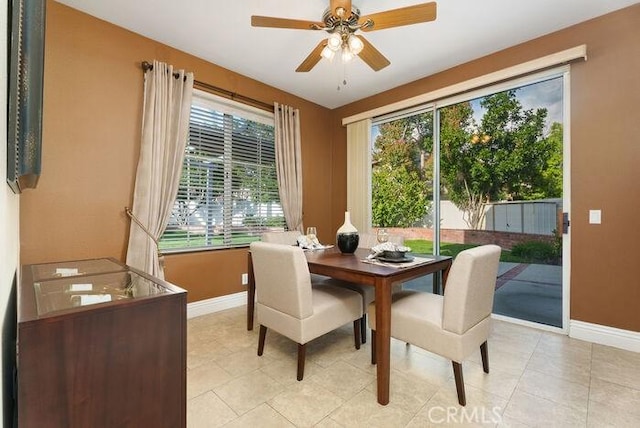 dining room featuring ceiling fan, baseboards, and light tile patterned floors