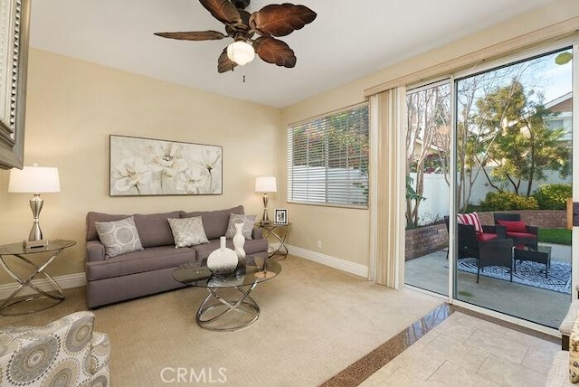 living area featuring ceiling fan, carpet floors, and baseboards