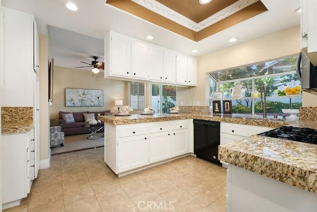 kitchen with black dishwasher, a peninsula, a raised ceiling, and white cabinetry