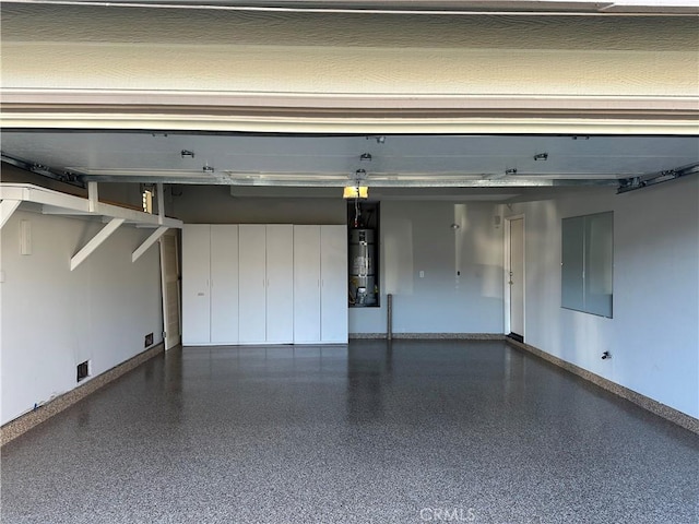 garage featuring secured water heater, visible vents, and baseboards