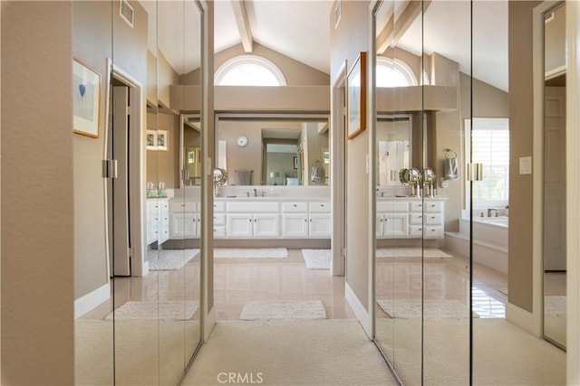 full bath featuring a garden tub, visible vents, lofted ceiling with beams, vanity, and baseboards