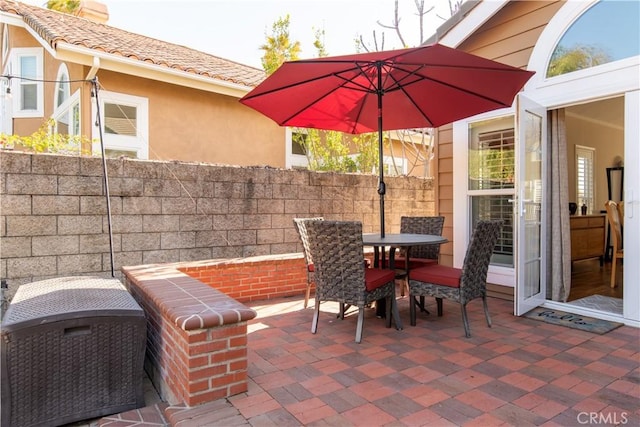 view of patio with outdoor dining area and fence