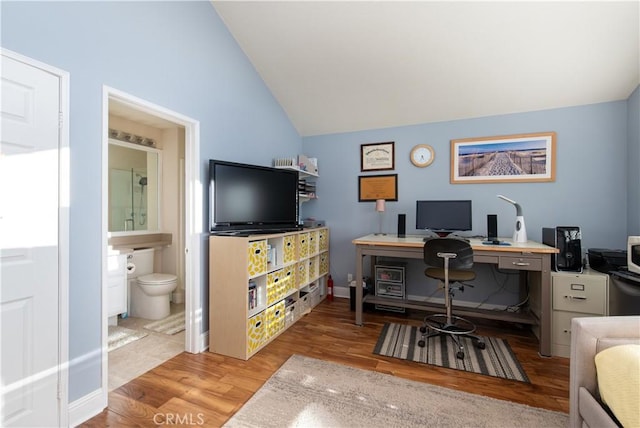 home office with vaulted ceiling and wood finished floors