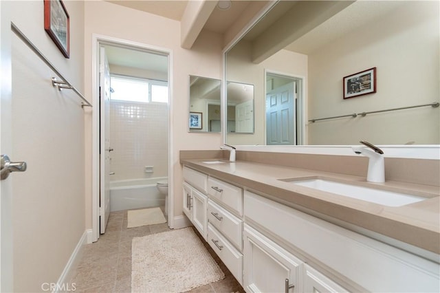 full bath with double vanity, baseboards, toilet, tile patterned floors, and a sink