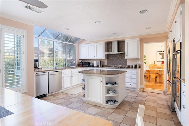 kitchen with stainless steel appliances, white cabinets, visible vents, and wall chimney range hood