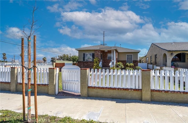 bungalow-style house featuring a fenced front yard and brick siding