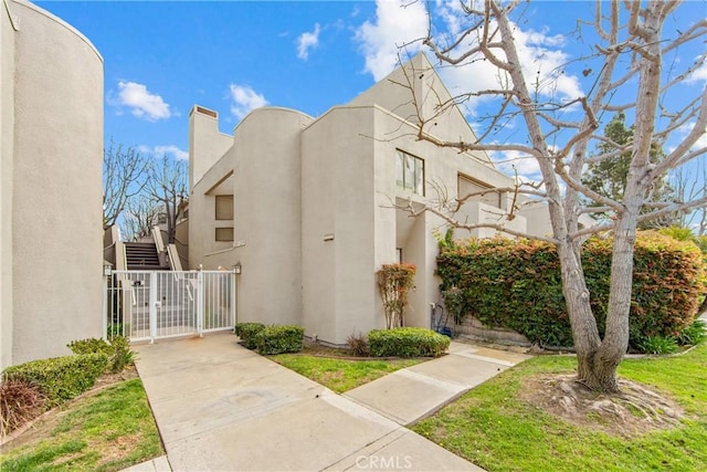 view of home's exterior with a gate and stucco siding