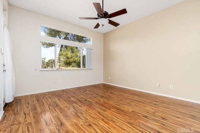 empty room with ceiling fan, baseboards, and wood finished floors