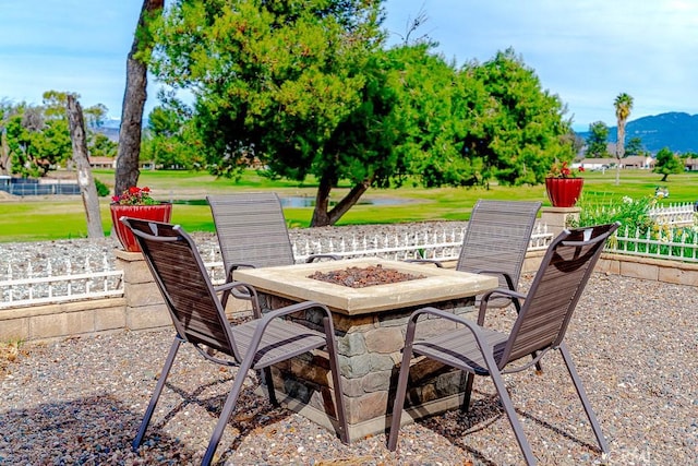 view of patio / terrace with a mountain view, a fire pit, and fence