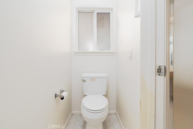 bathroom with tile patterned flooring, toilet, and baseboards