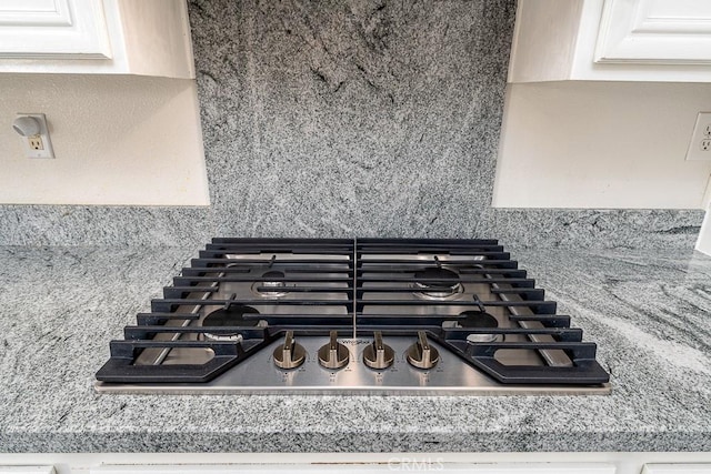 room details featuring white cabinets and stainless steel gas cooktop