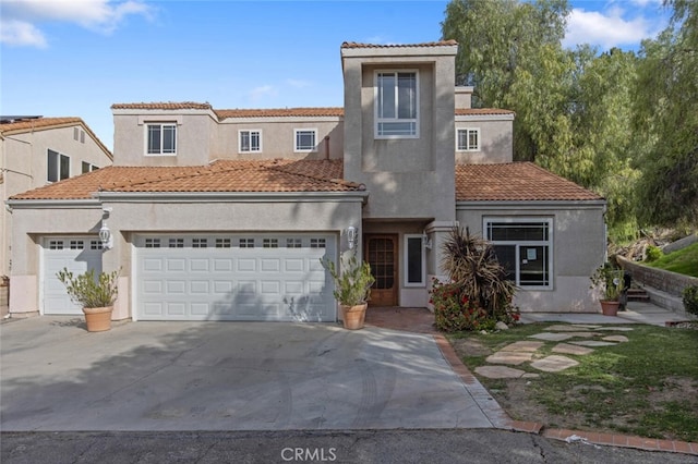 mediterranean / spanish-style home featuring a garage, a tile roof, concrete driveway, and stucco siding