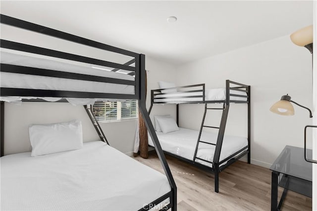 bedroom featuring light wood-style floors and baseboards