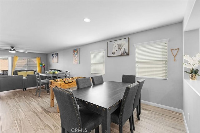 dining area with ceiling fan, plenty of natural light, light wood-style flooring, and baseboards