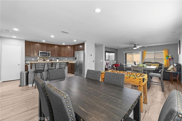 dining area with light wood finished floors, visible vents, and recessed lighting