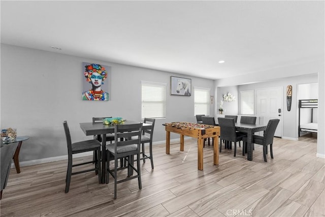 dining space featuring light wood-style flooring and baseboards