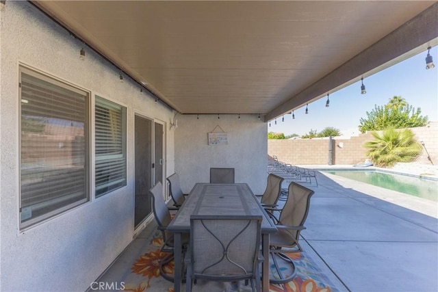 view of patio / terrace featuring outdoor dining space, a fenced backyard, and a fenced in pool