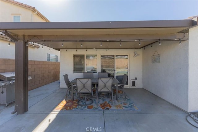 view of patio with outdoor dining space, area for grilling, and fence