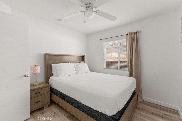 bedroom with light wood-style floors, baseboards, and a ceiling fan