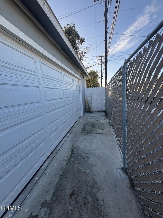 garage with driveway and fence