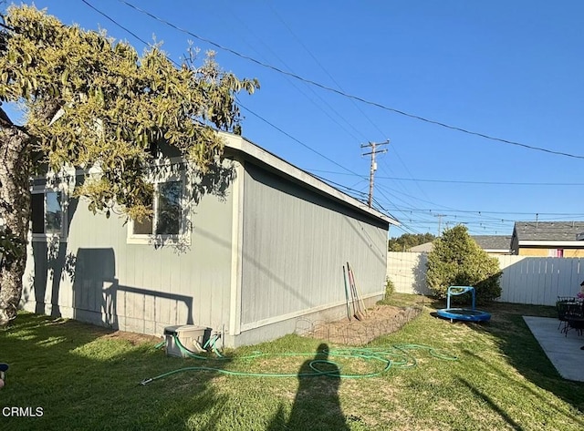 view of property exterior featuring fence and a lawn