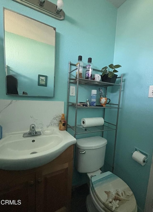 half bathroom with vanity and toilet