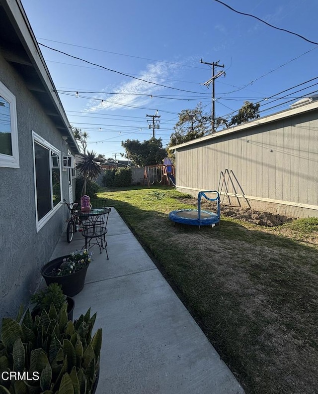 view of yard with a patio, a playground, and a fenced backyard