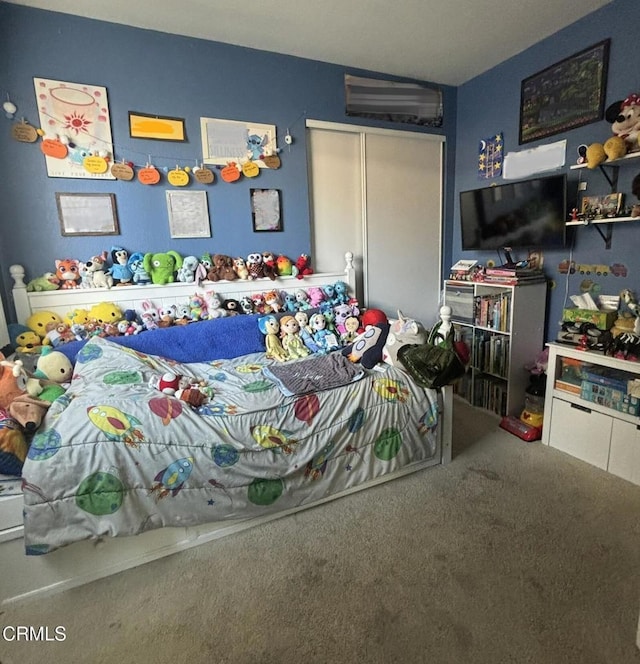 bedroom with carpet floors, a closet, and a wall unit AC