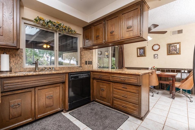 kitchen featuring light tile patterned floors, a peninsula, a sink, visible vents, and black dishwasher