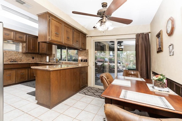 kitchen with a wealth of natural light, visible vents, a peninsula, and decorative backsplash