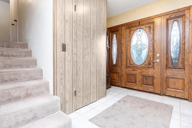 foyer with stairway and light tile patterned floors