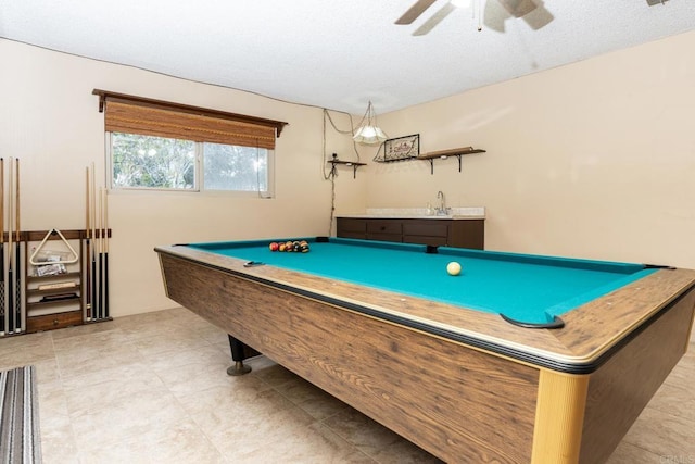 rec room featuring ceiling fan, indoor wet bar, pool table, a textured ceiling, and a sink