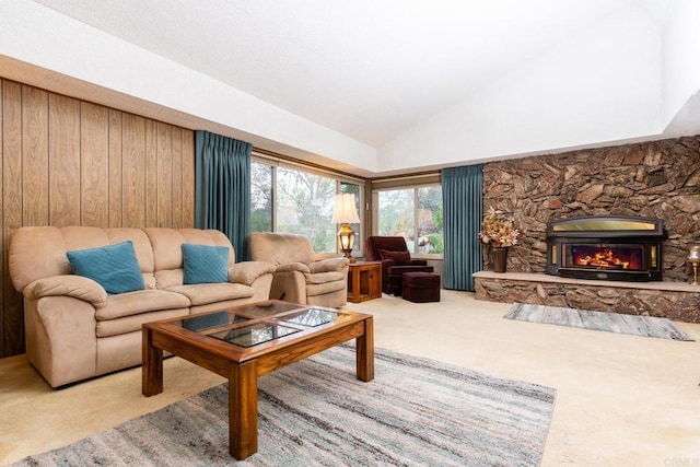 carpeted living area with high vaulted ceiling and a stone fireplace