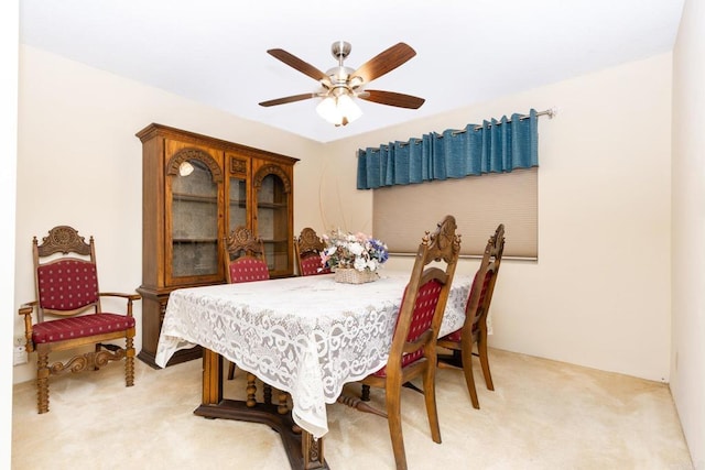 dining area with light colored carpet and ceiling fan