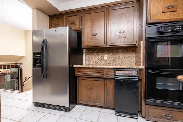 kitchen featuring stainless steel refrigerator with ice dispenser, dobule oven black, backsplash, brown cabinetry, and light tile patterned flooring