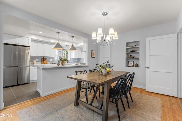 dining room featuring light wood-style flooring, recessed lighting, baseboards, and a chandelier