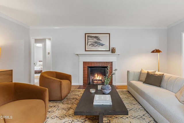 living area with a brick fireplace, crown molding, baseboards, and wood finished floors