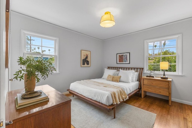 bedroom with baseboards and wood finished floors