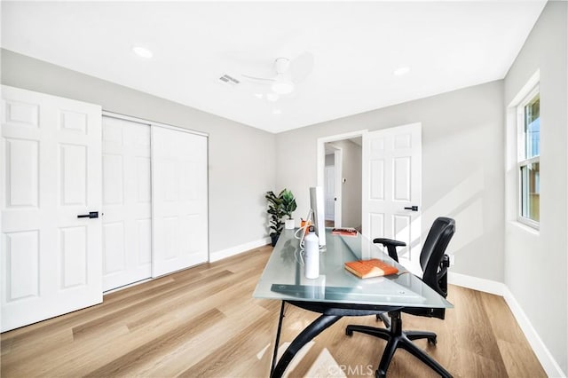 office area featuring a ceiling fan, visible vents, light wood-style flooring, and baseboards