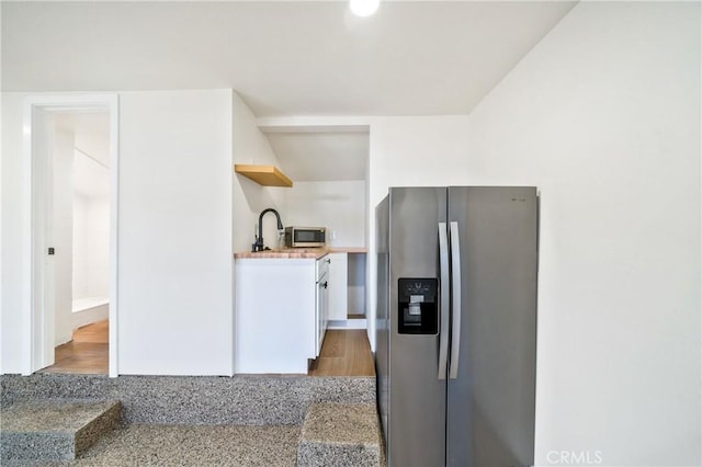 kitchen featuring appliances with stainless steel finishes, light countertops, white cabinets, and open shelves