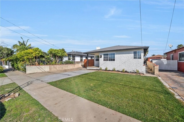 view of front of property with fence, a gate, stucco siding, a front lawn, and a chimney