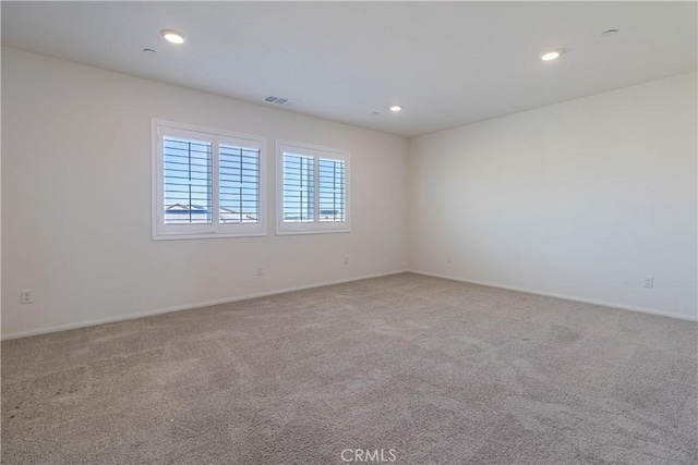 carpeted spare room featuring recessed lighting, visible vents, and baseboards