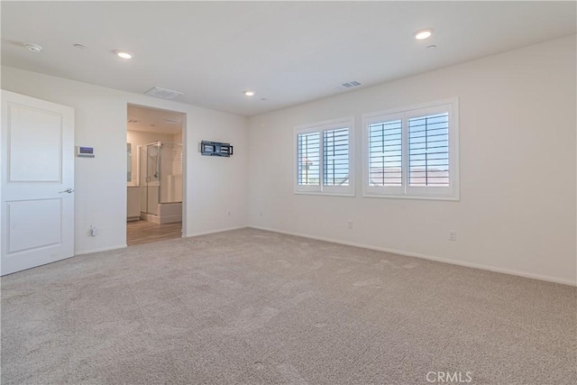 unfurnished room with recessed lighting, light colored carpet, baseboards, and visible vents