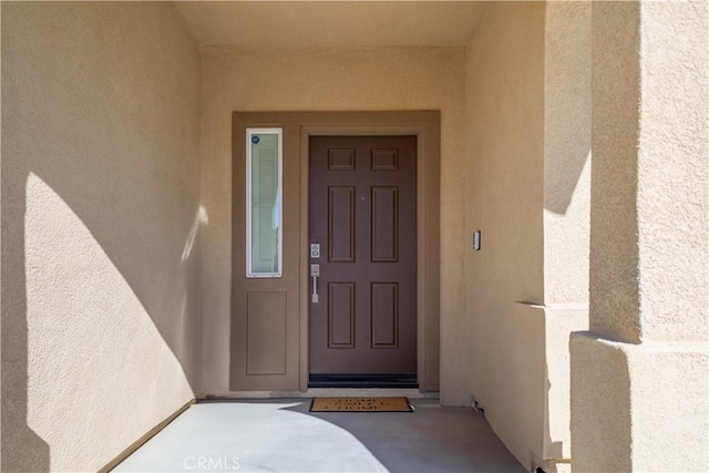 property entrance with stucco siding