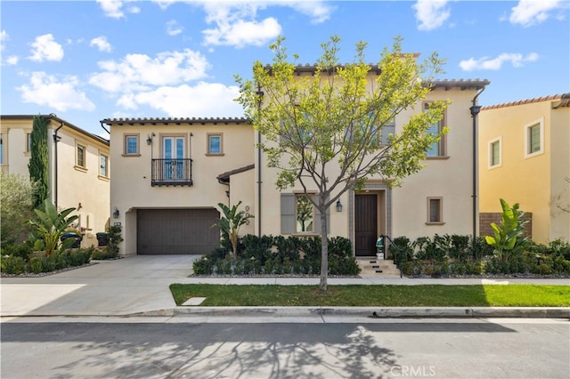 mediterranean / spanish-style house featuring a balcony, a garage, concrete driveway, a tiled roof, and stucco siding